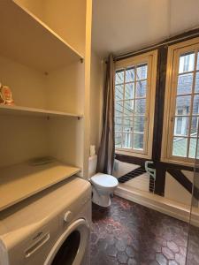 a bathroom with a toilet and a window at L'écrin Beauvoisine - Rouen Hyper Center in Rouen