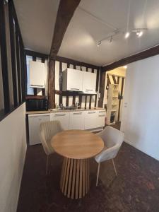 a kitchen with a wooden table and chairs in a room at L'écrin Beauvoisine - Rouen Hyper Center in Rouen +14 photos