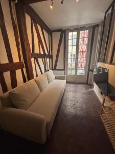 a living room with a white couch and a window at L'écrin Beauvoisine - Rouen Hyper Center in Rouen