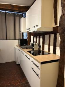 a kitchen with white cabinets and a counter top at L'écrin Beauvoisine - Rouen Hyper Center in Rouen