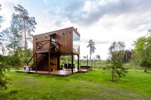 a wooden house with a glass facade in a field at Luxury Resort Orava in Orava