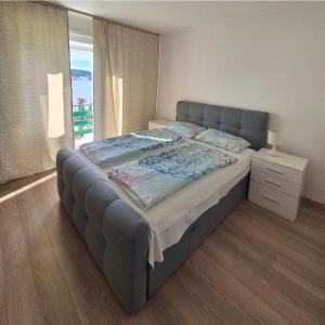 a large bed in a bedroom with a window at Apartmani Mira in Rab
