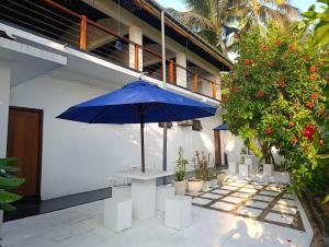 a blue umbrella sitting on a table next to a building at Anara Villa in Unawatuna