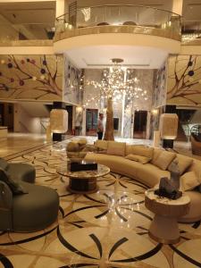 a lobby with a couch and chairs and a chandelier at La Belle - The Business Hotel in Lubumbashi +1 photo