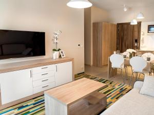 a living room with a large flat screen tv at VacationClub - Baltic Park Molo Apartment D203 in Świnoujście