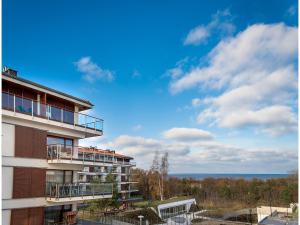 シフィノウイシチェにあるVacationClub - Baltic Park Molo Apartment D203の海の景色を望むアパートメントビル