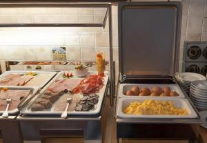 a kitchen with two trays of meat and eggs at Das Landhotel Weingut Gernert in Sankt Martin