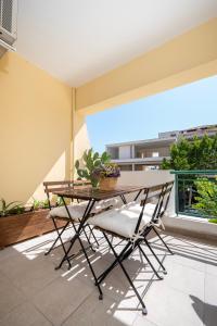 a table and chairs on a balcony with a window at Warmth & Charm Island Style in Kos