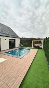 a backyard with a swimming pool and a wooden deck at Çavdi Villa in Ardeşen