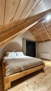a large bed in a room with a wooden ceiling at Çavdi Villa in Ardeşen +9 photos