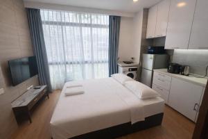 a bedroom with a large bed and a kitchen at Oxley Thanksgiving Residence in Singapore +38 photos