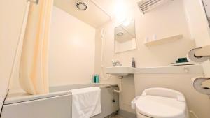a small bathroom with a toilet and a sink at Hotel Route-Inn Aomori Ekimae in Aomori