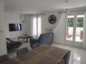 a living room with a wooden table and chairs at Maison agréable, emplacement idéal in Sainte-Suzanne