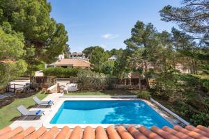 a swimming pool in the yard of a house at Villa Misuco by 3VILLAS in Son Parc