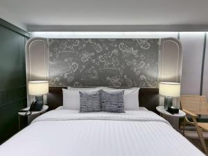 a bedroom with a large white bed with a wall at The Quarter Chaophraya by UHG - Riverfront Hotel, Walk to ICONSIAM in Bangkok +210 photos