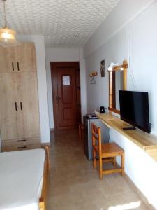 a room with a desk with a tv and a chair at Ethra in Patitiri