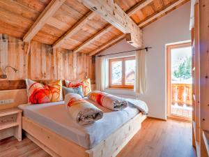 a large bed in a room with wooden walls at Berghütte Kneisl in Sölden