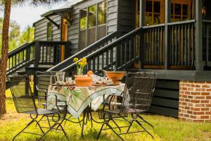 a table and chairs on a lawn in front of a house at Little Pine Lodge At Saddlecreek in Thomasville