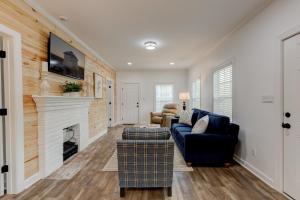 a living room with a couch and a fireplace at Mimosa Cottage - Thomasville Charm in Thomasville