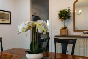a vase filled with white flowers on a table at Mimosa Cottage - Thomasville Charm in Thomasville +32 photos