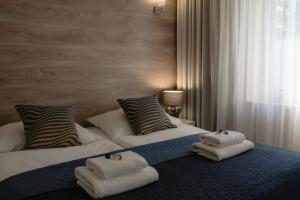 a bedroom with two beds with towels on them at Villa Flaming in Sopot