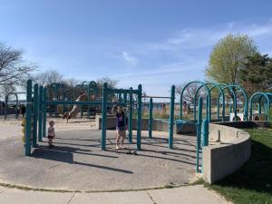 a woman and a child playing in a playground at Cozy Updated Queen Ground Floor Studio in Muskegon