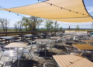 a group of tables and chairs with a large umbrella at Modern Queen Studio At The Victorian - Unit B in Muskegon