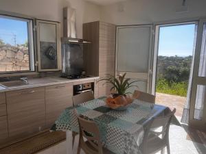 a kitchen with a table with a bowl of fruit on it at villa ingrassia in Favignana