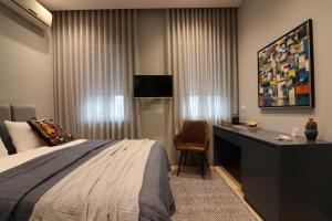 a bedroom with a bed and a desk with a chair at Rroji Urban Heritage - Boutique Rooms & Serviced Apartments in City Center in Shkodër