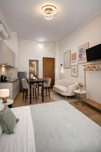 a living room with a table and a kitchen at Aurora Apartments in Mytilene