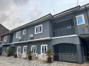 a blue building with plants in front of it at AG Sigma Apartments in Port Harcourt