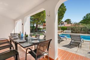 a patio with a table and chairs next to a swimming pool at Villa Misuco by 3VILLAS in Son Parc +19 photos