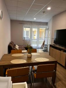 a room with a table and chairs and a television at Mnd Aqua Nest in Zalakaros