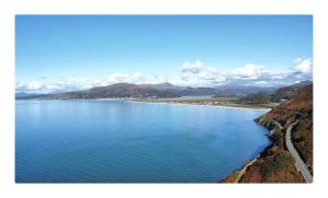 a large body of water with mountains in the background at Caban Caru 2 in Tywyn