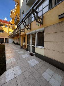 an empty sidewalk next to a building with windows at Mnd Aqua Nest in Zalakaros