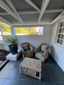 two wicker chairs and a table on a porch at Maple and Vine in Hilton