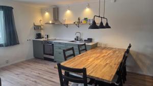a kitchen with a wooden table and a table and chairs at Lagom huset in Årjäng
