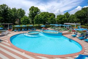 a pool at a resort with chairs and umbrellas at Hotel Smeraldo in Cesenatico