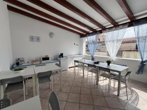 a kitchen with white tables and chairs in a room at Mamamia #Lipari in Lipari