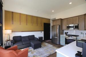 a living room with a couch and a kitchen at Chic Queen Apartment At The Victorian Unit A in Muskegon