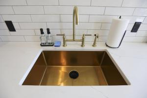a stainless steel sink in a white kitchen at Chic Queen Apartment At The Victorian Unit A in Muskegon +16 photos