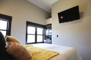 a bedroom with a bed with a television on the wall at Chic Queen Apartment At The Victorian Unit A in Muskegon