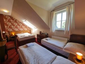 a hotel room with three beds and a window at Rezydencja Pałac Lucja BB in Zakrzów