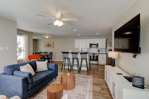 a living room with a blue couch and a kitchen at Mimosa Getaway - Thomasville Fun! in Thomasville