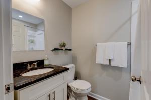 a bathroom with a sink and a toilet and a mirror at Mimosa Getaway - Thomasville Fun! in Thomasville +32 photos