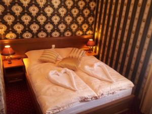 a bed with two towels on it with two lamps at Rezydencja Pałac Lucja BB in Zakrzów