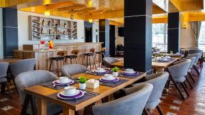 a restaurant with wooden tables and chairs and a bar at Yashshree Dewathang Resort in Lachung