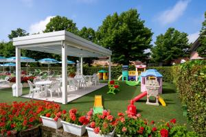 a garden with a playground and a pavilion at Hotel Smeraldo in Cesenatico
