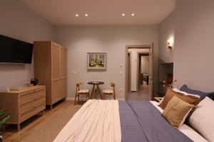a bedroom with a large bed with a dresser and a table at Rroji Urban Heritage - Boutique Rooms & Serviced Apartments in City Center in Shkodër +158 photos