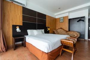 a bedroom with a large bed and a chair at Sipadan Inn 2 in Semporna +24 photos